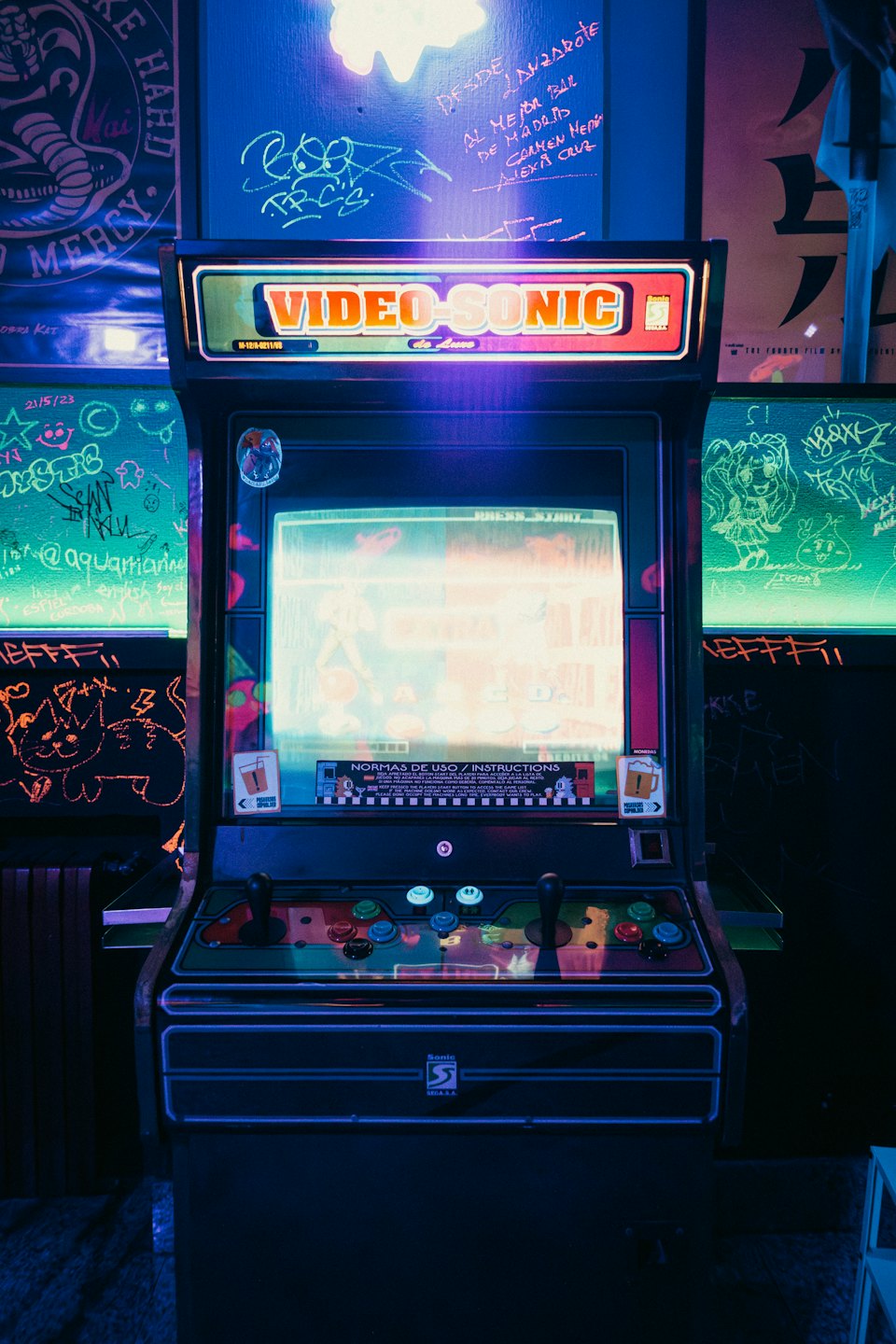 Vintage VIDEO-SONIC arcade game in a dark, graffiti-covered room.